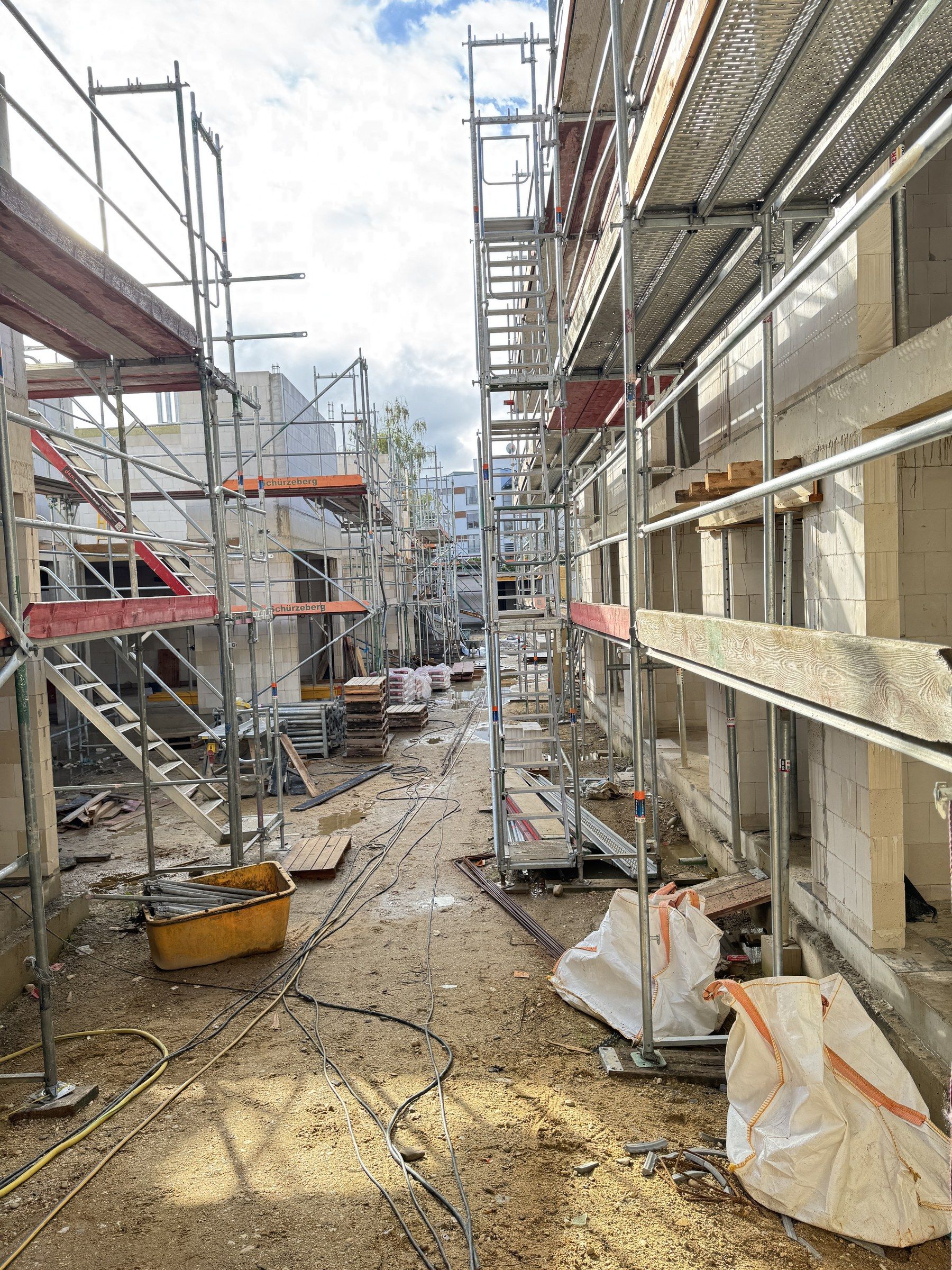 Die Gasse zwischen den Häusern im Rohbau, eingerüstet